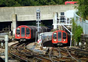 Two Central line trains side by side.