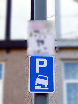 Permitted to park with one side of vehicle on kerb road sign.
