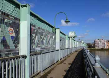Train seen from footpath on Fulham Railway Bridge.