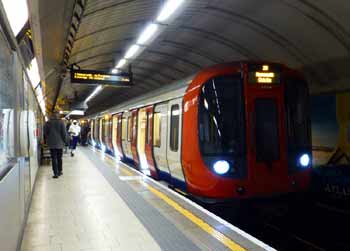 Westbound S stock underground train at Kings Cross St Pancras station subsurface platform.