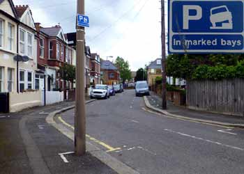 Permitted to park with one side of vehicle on kerb road sign.