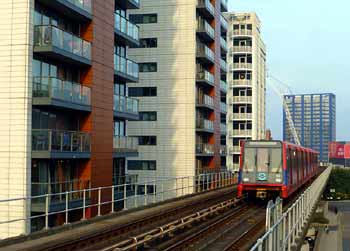 London DLR train passing high density tower block dwellings.