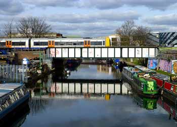Overground train crosses river Lea.