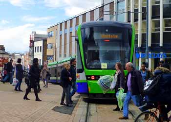 Tramlink tram and pedestrians in central Croydon.