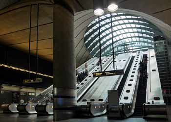 Bank of 5 escalators Canary Wharf station.