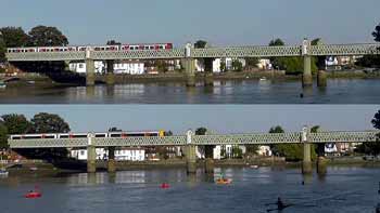 Kew Railway Bridge with Underground and Overground trains and canoeists on River Thames.